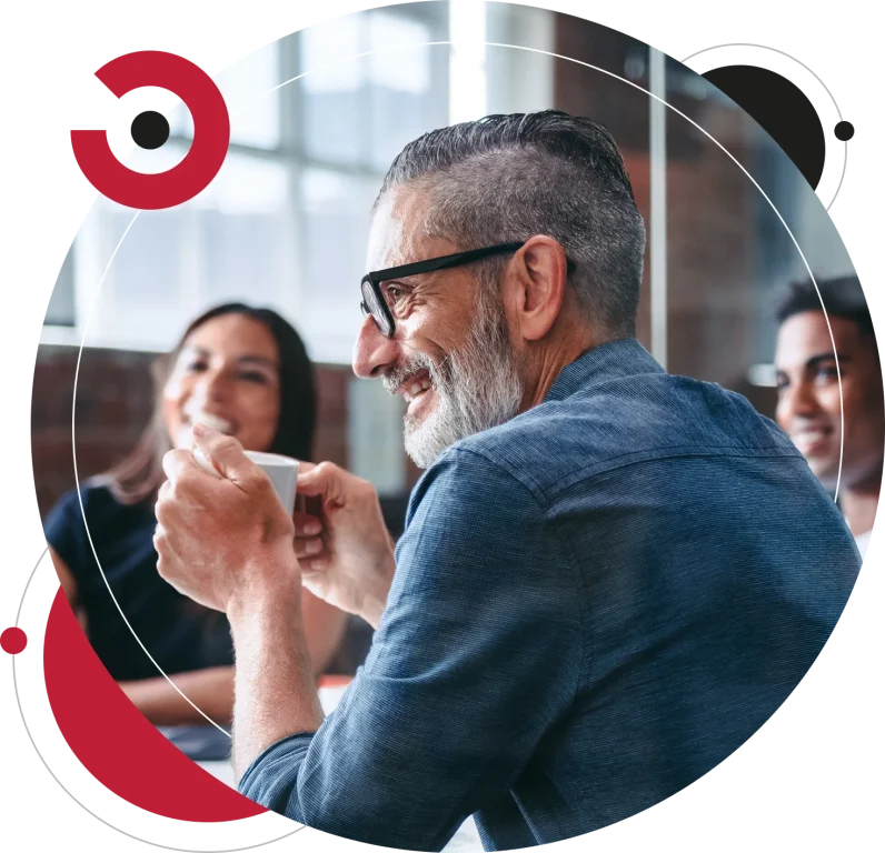 Experienced businessman smiling while sitting with his business partners in a meeting room.